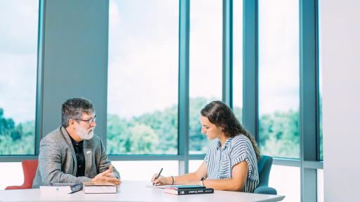 Professor and student at table