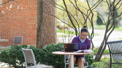 student sitting outside doing homework