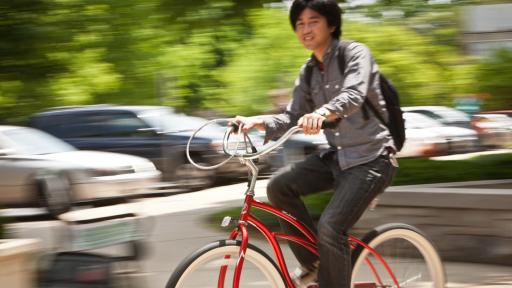 student riding red bike outside