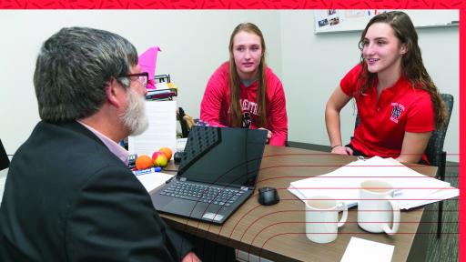 Dr. Kelley in his office with students