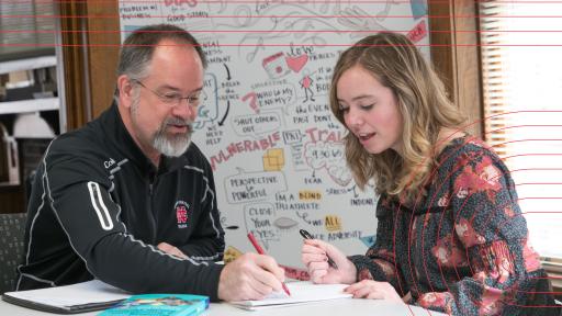 Professor at table with student