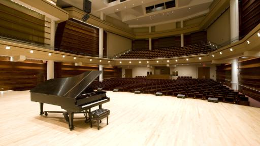 A lone piano on the stage of Wentz Concert Hall.