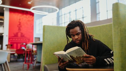 A North Central College student reading a textbook.