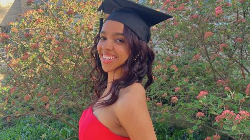 A portrait of Raygn Jordan ’24 smiling and wearing a red dress and black graduation cap.