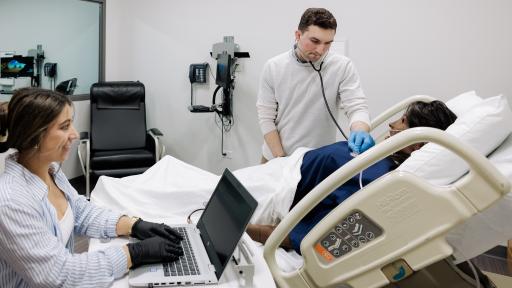 A photo of two nursing students working in a classroom.