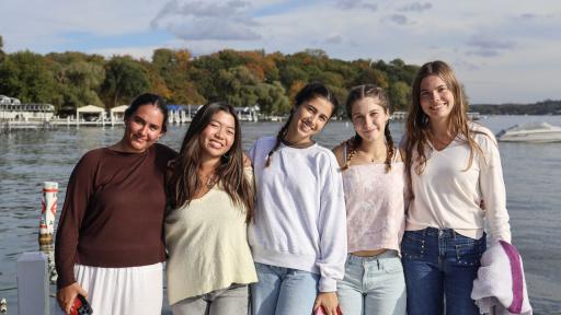 students posing in front of a lake