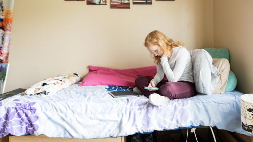 student calling on dorm bed