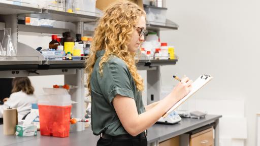 student taking notes in a laboratory