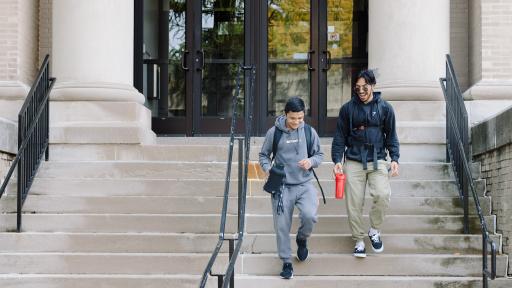 Two students walking down stairs