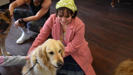 Student petting a golden retriever