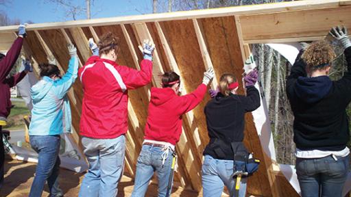 Students raising a wall at a Habitat for Humanity project.
