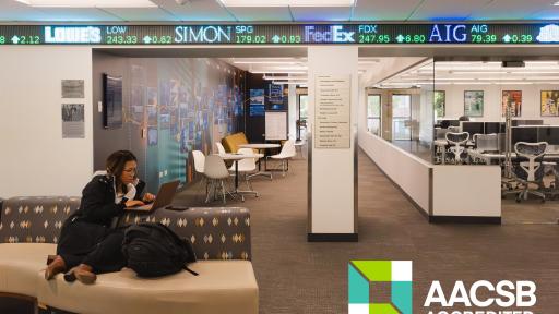 a student studying in a seating area, with the Bloomberg Lab in the background