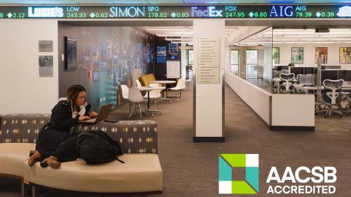 a student studying in a seating area, with the Bloomberg Lab in the background