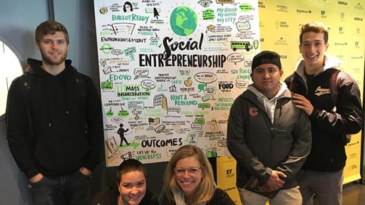 Professor Whitney Roberts and her students presenting an infographic poster on social entrepreneurship.