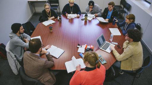 A group of students around the eight-sided Shimer table.